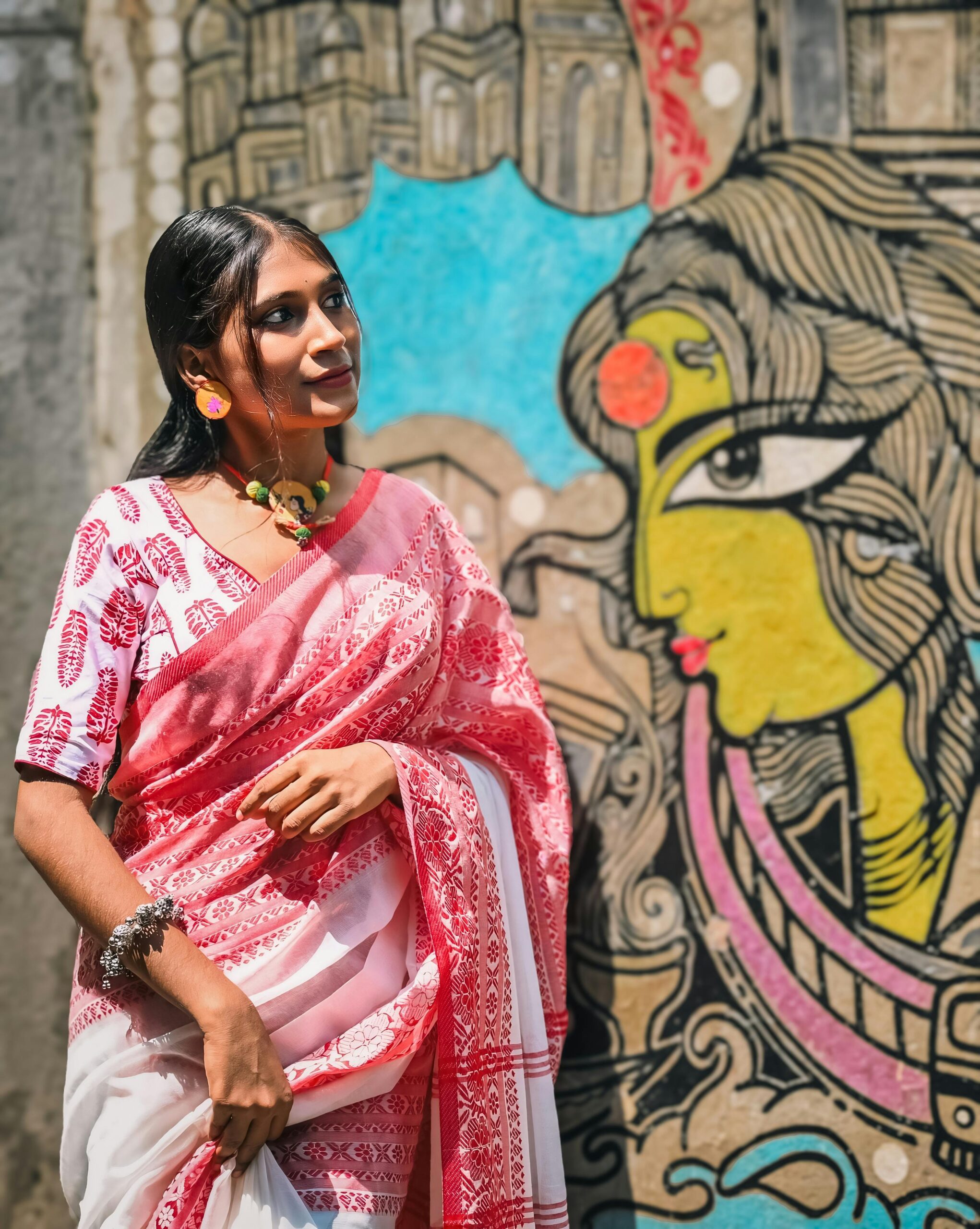 Young woman in traditional attire standing by colorful street in Kollam Wedding Dress Shop