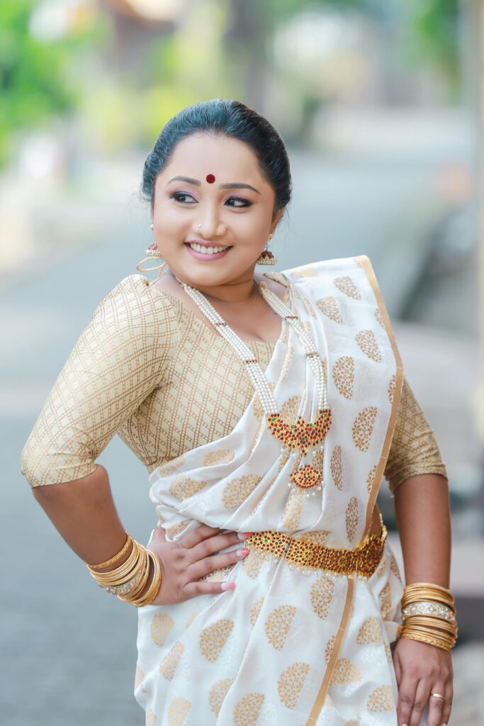 Beautiful woman in traditional Indian saree smiling outdoors, exuding confidence and grace.