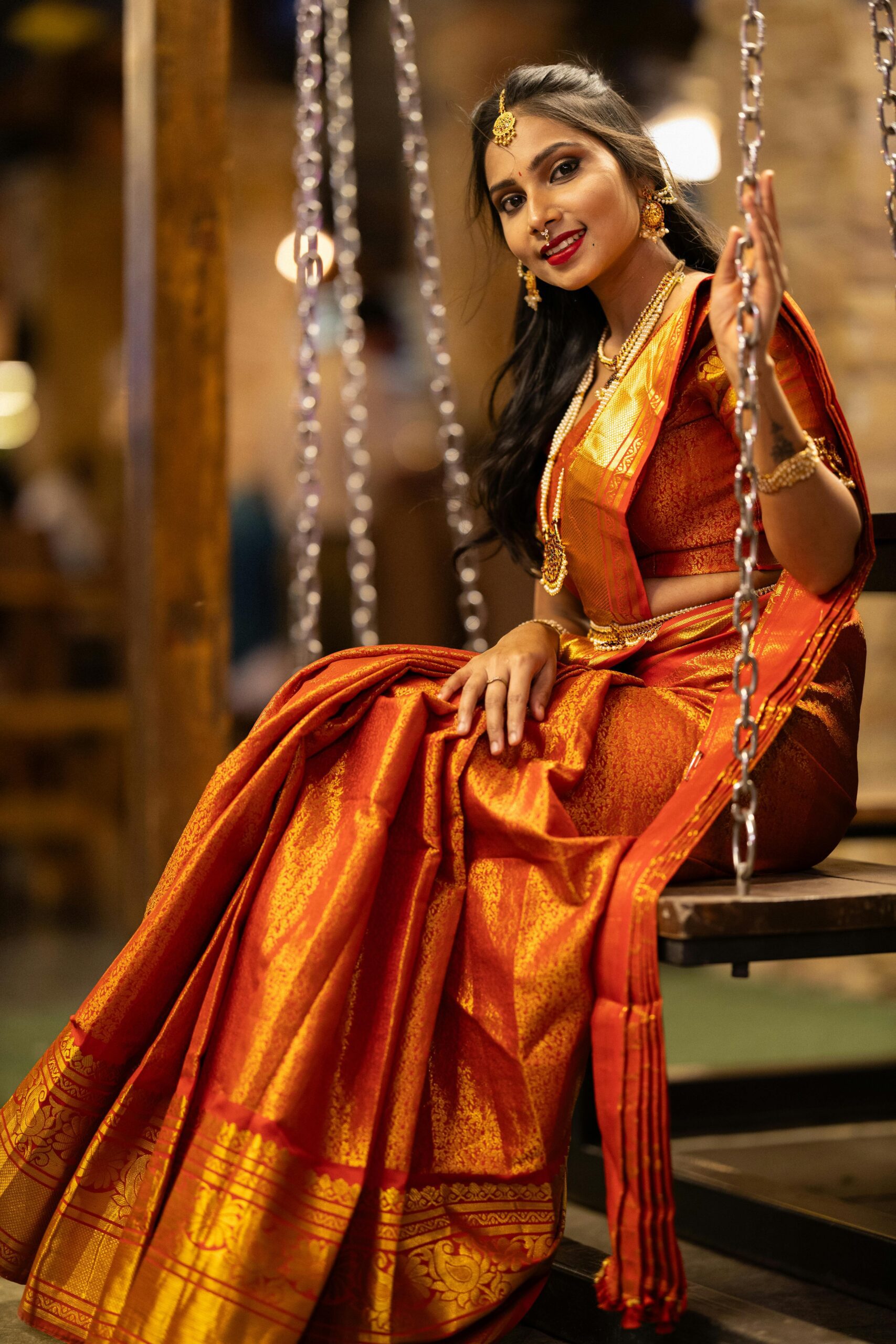 Beautiful woman in a traditional saree with gold jewelry, exuding elegance.