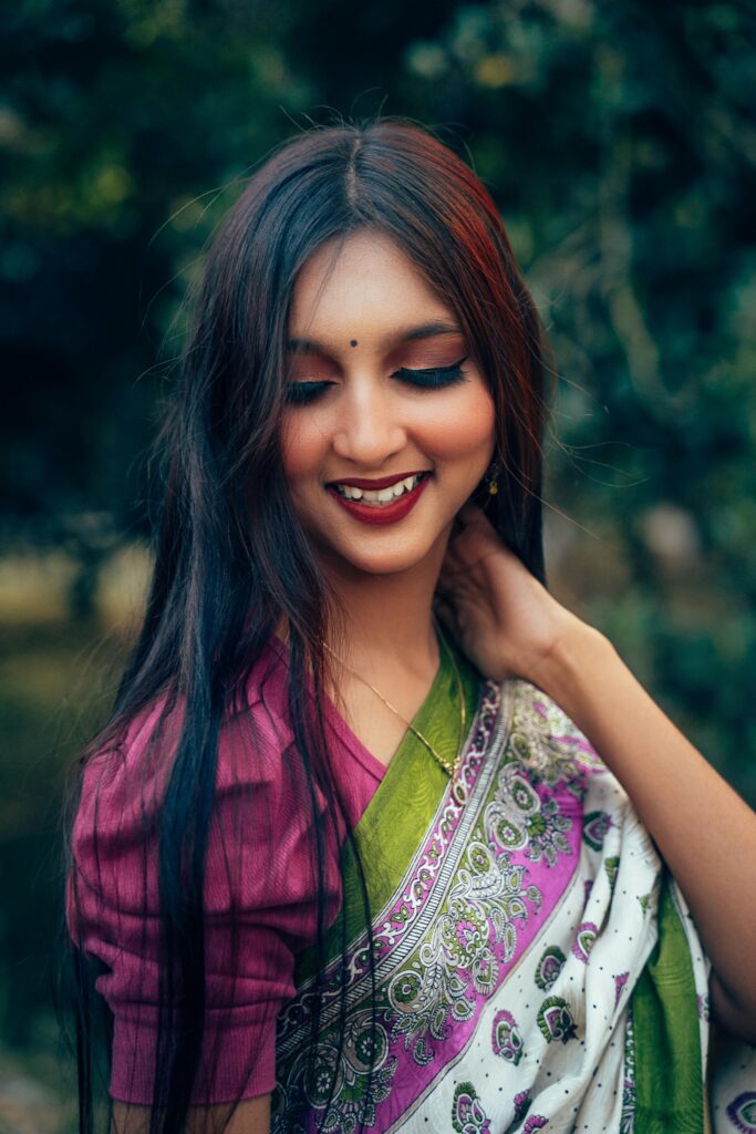 A graceful adult woman in a traditional saree, showcasing cultural beauty in a natural setting.