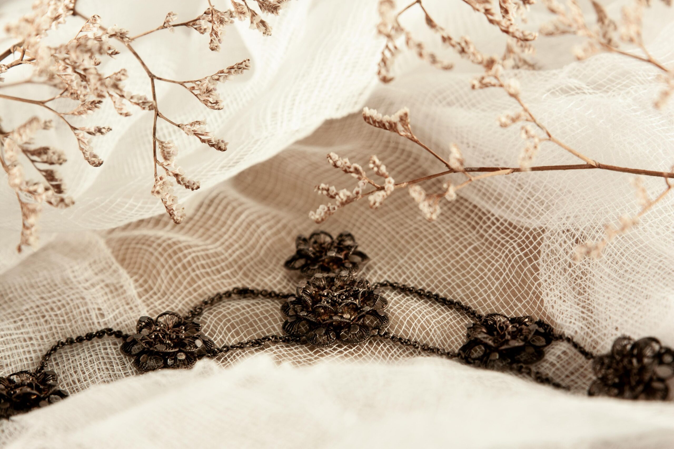 Close-up of delicate lace with floral embellishments on soft fabric, creating a vintage aesthetic.